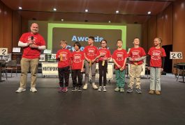 People posing on stage at an awards ceremony.