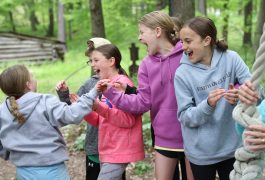 Girls playing tug of war in a park.