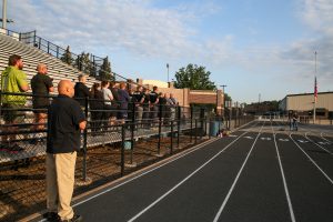 People standing on a track at an event.