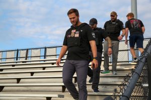 Men walking up bleachers at stadium.