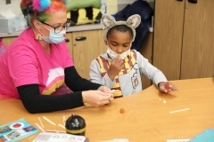 Two people at a table working on pumpkin catapults.