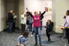 People in a room celebrating spring fest, some are dancing while others look on, all wearing casual clothes.