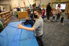 Children in a library participating in a fishing activity.