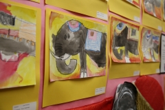 An art display featuring a collection of drawings of elephants in various styles and colors.