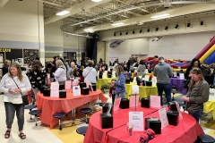 People gathered in a gymnasium for a fundraiser event.