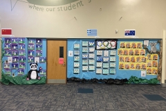 The bulletin board is filled with colorful posters and drawings, including a panda, a fish, and a tree, arranged in rows.