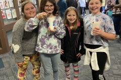 Four girls posing in front of a building during spring fest.