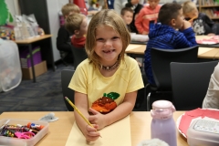 Young girl sitting at a desk in a classroom.