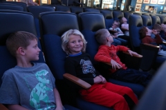 Children sitting in movie theater seats.