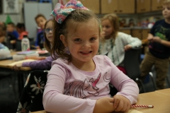 Little girl sitting at a desk in a classroom.