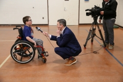 Man in wheelchair interviewing man standing next to him.