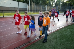Children walking in a line on a track during a walkathon event.