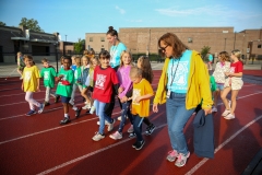A group of people walking together in a line on a track.