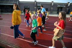 People walking in a line on a track during a walkathon event.