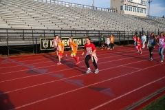 People running in a stadium during a walkathon event.