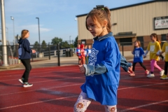 Girl in blue shirt walking on track during walkathon.