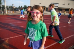 Little girl in green shirt and pink glasses at a walkathon event.