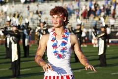 Man in red, white, and blue outfit standing on football field.