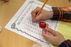 Person writing on a worksheet at a desk.