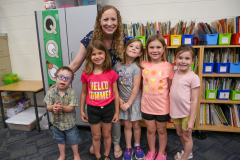Woman in front of children at a library.