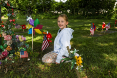 Girl in front of colorful grave decorations.