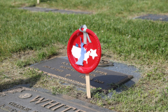A small red, white, and blue flag on a grave marker.