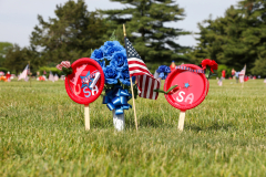 American flags and wreaths on poles in a field, commemorating Memorial Day.