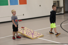 Two young boys playing a game in a gymnasium.