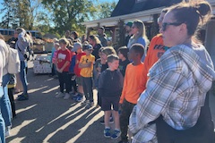 People standing in a group outside during the day.