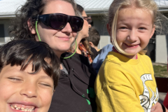Family of three enjoying a day out at an apple orchard in autumn.