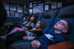 People watching a movie in a dark room.