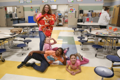 A group of people posing for a picture in a school cafeteria.