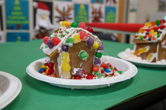 Gingerbread houses on a table, decorated with candy and icing, ready for Christmas celebration.