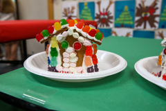 Gingerbread houses decorated with candy, placed on a green tablecloth.