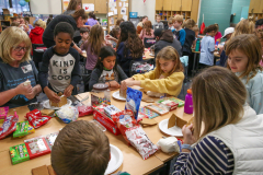 People gathered around a table filled with snacks, engaging in conversation.