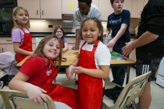 Children in a classroom setting, engaged in an activity, possibly making gingerbread houses for Christmas.