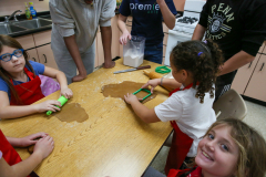 Children engaged in a gingerbread house making activity at school.