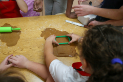 Children making gingerbread houses at a table.