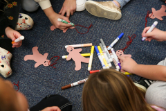 Children sitting on floor working on crafts.
