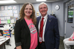 Two people posing for a picture in an office setting.