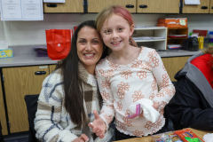 Woman and young girl posing together in a classroom setting.