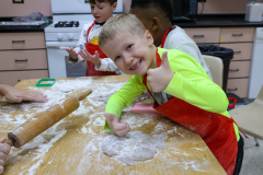 Young boy in a kitchen making gingerbread cookies.