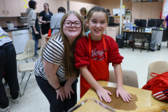 Two people posing in a kitchen classroom setting.