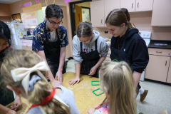 People in a kitchen preparing food together.