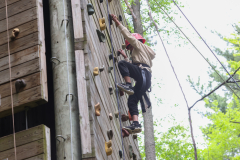 Person climbing a rock wall at an outdoor facility.