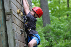 Child climbing a rock wall at camp.