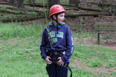 This is a person wearing a helmet and holding a rope while standing in an outdoor area.