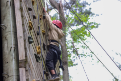 Child climbing a rock wall at camp.