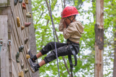 Child climbing a rock wall at camp.