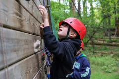 Two people climbing a rock wall at an outdoor facility.